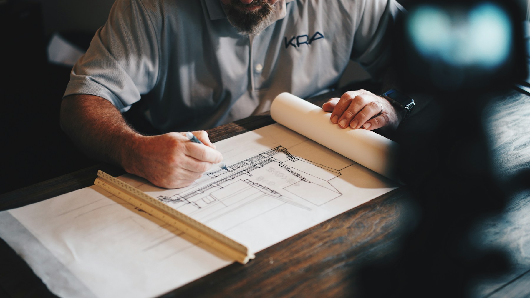 Gloved hands verifying a precise timber, stone, and metal construction detail